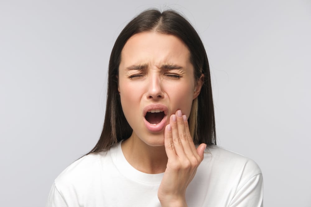 Toothache.,Studio,Shot,Of,Young,Woman,Feeling,Pain,,Holding,Her